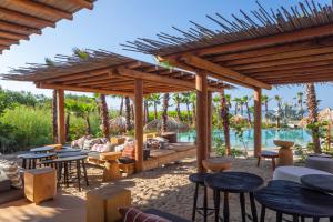 a wooden pavilion with tables and chairs and a pool at Kymaia Hotel Puerto Escondido in Tlachicón