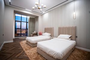 a bedroom with two beds and a chandelier at شاليه مسا الفندقي in Buraydah +39 photos