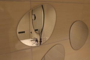 a bathroom with a sink with two mirrors on the wall at Åsjord Farmhouse in Oldra +23 photos