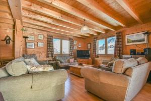 un soggiorno con due divani e una TV di Chalet Berrier a Le Grand-Bornand