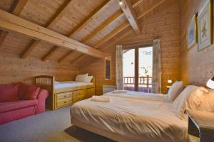 una camera da letto con un letto e un divano in una stanza di Chalet Berrier a Le Grand-Bornand