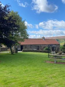 een huis met een picknicktafel in een tuin bij Craven Garth Cottages in Rosedale Abbey