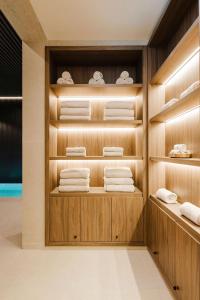 a walk in closet with wooden shelves and towels at Lisbon Chiado Hotel & Spa in Lisbon