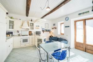 a kitchen and living room with a glass table at Patresi Mare - Goelba in Mortigliano +15 photos