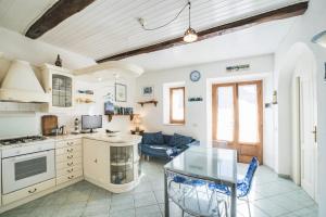 a kitchen and living room with a glass table at Patresi Mare - Goelba in Mortigliano