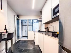 a kitchen with white cabinets and a black floor at El Balcón de Machado in Soria