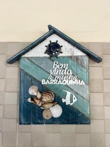 a sign on the side of a building with shells at Casa Aconchegante Tamandaré in Tamandaré