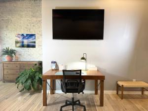 an office with a desk with a chair and a television at The Benjamin Hotel in Watkins Glen
