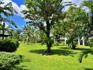 eine Palme inmitten eines Grasfeldes in der Unterkunft Allamanda Laguna Phuket by RESAVA in Strand Bang Tao