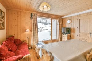 un salon avec une table et un canapé dans l'établissement Refuge Le Bardeau B1, au Grand-Bornand