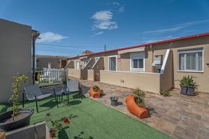 un pequeño patio trasero con un patio con césped en 2 Apartamentos Omanai Tenerife Sur, en Las Galletas