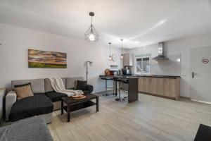 Una sala de estar con un sofá y una mesa y una cocina. en 2 Apartamentos Omanai Tenerife Sur, en Las Galletas