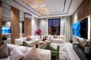 a living room with white couches and a large aquarium at شاليه مسا الفندقي in Buraydah