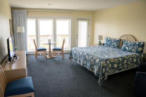 a bedroom with a bed and a table and chairs at Surf & Sand Beach Motel in South Yarmouth +39 photos