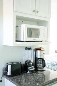 a kitchen counter with a blender and a microwave at Surf & Sand Beach Motel in South Yarmouth