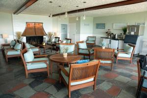 a lobby with chairs and tables and a fireplace at Surf & Sand Beach Motel in South Yarmouth