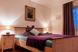 BitschArve的一间卧室配有一张带紫色床单的床和窗户。