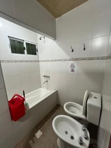 a white bathroom with a toilet and a sink at Complejo turístico Anto in Puerto Rico