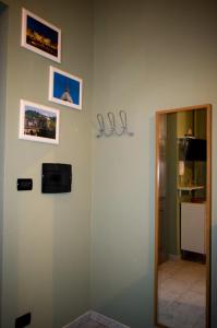 Una habitación con una pared con cuadros y un espejo. en Monginevro 15 min from the center, en Turín