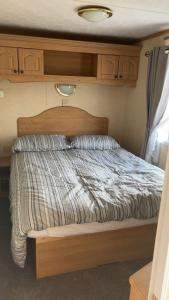 a bed with a striped comforter in a room at My happy place in Greencastle