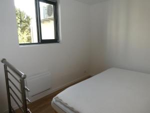 une chambre avec un lit et une fenêtre dans l'établissement Les Amarres, maison bois avec terrasse proche mer, à La Rochelle