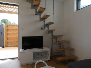 - un salon avec une télévision et un escalier dans l'établissement Les Amarres, maison bois avec terrasse proche mer, à La Rochelle