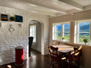 IsfjordenにあるGrey Lodgeのテーブルと2つの窓があるダイニングルーム