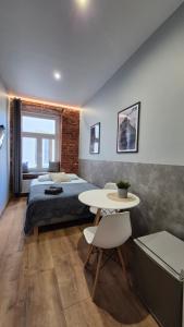 a bedroom with a bed and a table in it at Apart Complex Green Rewolucji 27 in Łódź