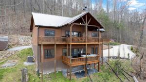 ein Haus mit einer umlaufenden Terrasse im Wald in der Unterkunft Winter Deal! 2 Master Suites, Fireplace, Hot tub in Sevierville