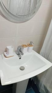 a white bathroom sink with two cups and a mirror at Modern 3BR Sea & Mountain View Apartment Bouar, Keserwan in Bqāq ad Dīn +30 photos