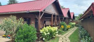 una casa con techo rojo y jardín en Betyár Apartmanházak Tiszafüred, en Tiszafüred