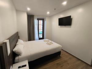a hotel room with a bed and a flat screen tv at HeyWelcome Valladolid Centro in Valladolid