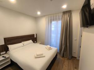 a bedroom with a bed with two towels on it at HeyWelcome Valladolid Centro in Valladolid +28 photos
