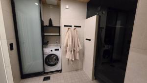 a small bathroom with a washing machine and a washer at Arctic Circle Aurora Guesthouse in Rovaniemi