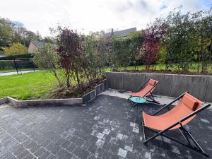 two chairs and a table on a patio at Appart Wavre, 2ch, terrasse, piscine, charme & confort in Wavre