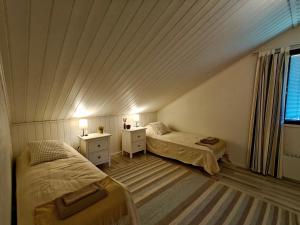 une chambre mansardée avec deux lits et une fenêtre dans l'établissement Lapland Oasis, à Rovaniemi