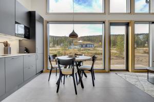cocina con mesa y sillas y ventana grande en Deluxe Luosto, en Luosto