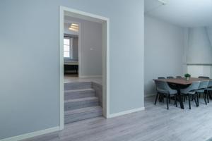 a dining room with a table and chairs and a staircase at MAYA Apartments - Sentrum in Oslo +34 photos