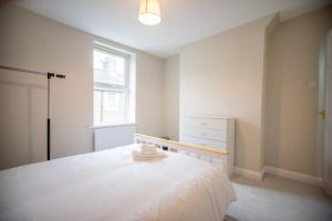 ワーキントンにあるYour Perfect Home Away From Homeの白いベッドと窓のある寝室