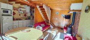 a kitchen and dining room with a table and a staircase at Lou cridadé in Laruns