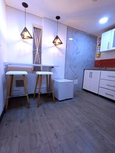 ボゴタにあるHotel Boutique CGH Aeropuertoのキッチン(スツール2脚、テーブル付)