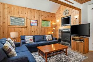 a living room with a blue couch and a tv at Twin Rocks Hideaway in Rockaway Beach