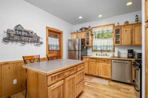 a kitchen with wooden cabinets and a stainless steel refrigerator at Twin Rocks Hideaway in Rockaway Beach