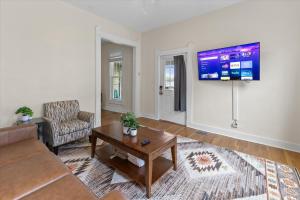 a living room with a couch and a tv on a wall at Simple Comfort 1 Bed 1 Bath Near Downtown Indy in Indianapolis