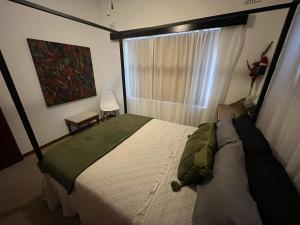 Un dormitorio con una cama grande y una ventana. en Summer Suite, en Hermanus