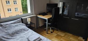 a bedroom with a bed and a desk with a computer at Apartament Gdynia Babie Doły in Gdynia