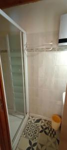 a shower with a glass door in a bathroom at Lou cridadé in Laruns