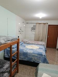 a room with two beds in a room at Pousada Nosso Cantinho in Guarapari
