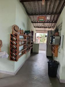 a room with a counter with wine bottles and a refrigerator at Pousada Nosso Cantinho in Guarapari