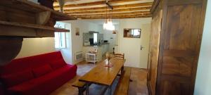 a living room with a red couch and a wooden table at Bouerzy in Laruns +9 photos